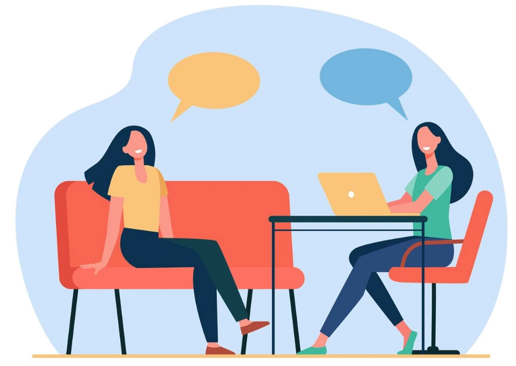 Two people chatting in an office with a laptop